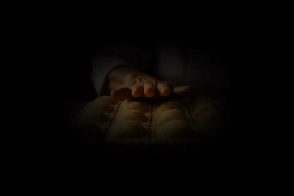 Las manos del chef acomodando raviolis recién cortados sobre la tabla enharinada